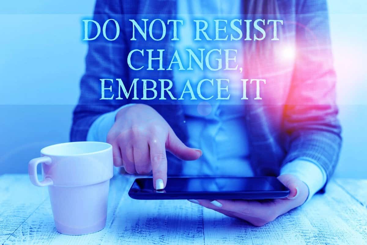 Person using a smartphone with a coffee cup nearby and text overlay saying "do not resist change, embrace it" in a motivational style about reducing heart failure risk.