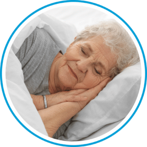 An older person peacefully sleeping on their side, head resting on a pillow, hands clasped under cheek, as their trusty sleep buddy.