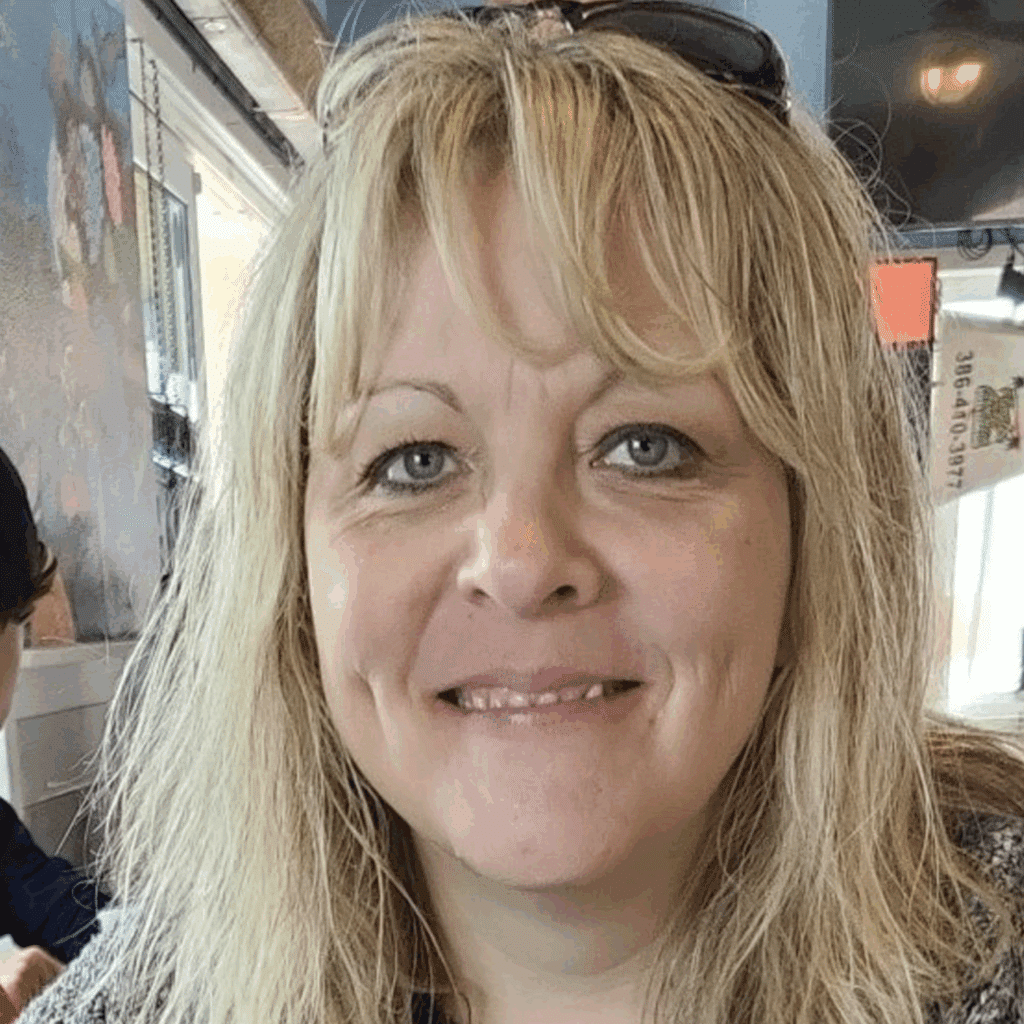 A woman smiling at the camera, radiating confidence as one of many inspiring weight loss success stories.